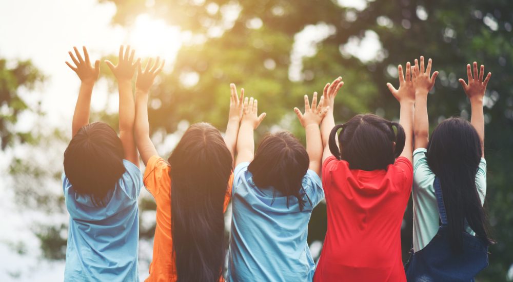 Group of kids friends arm around sitting together